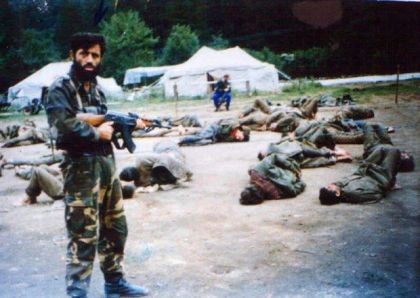 Припадник одреда Ел муџахид поред заробљених српских војника